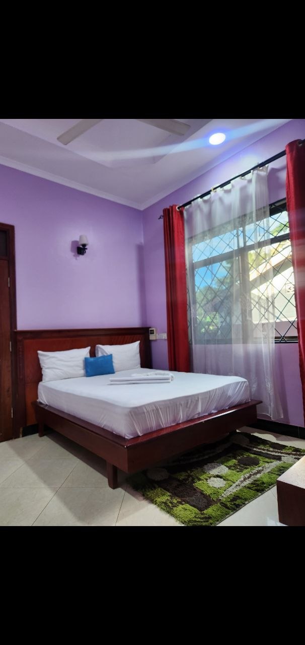 Spacious king bedroom with red curtains